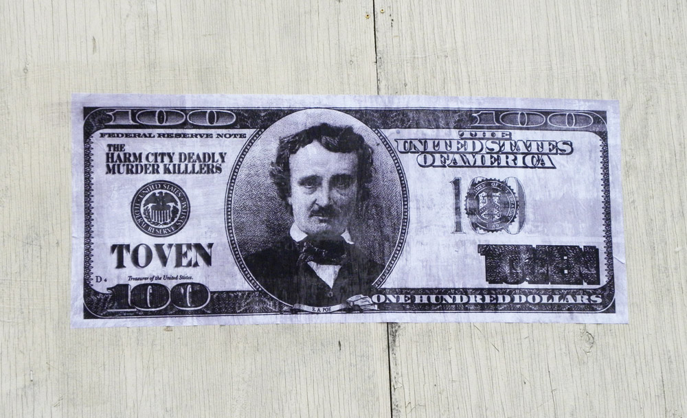 This is a wheatpaste of Edgar Allan Poe on a one hundred dollar bill, "Poe Dough", by the Baltimore street artist TOVEN.  You can see more of TOVEN's work here - http://www.flickr.com/photos/65757968@N00/